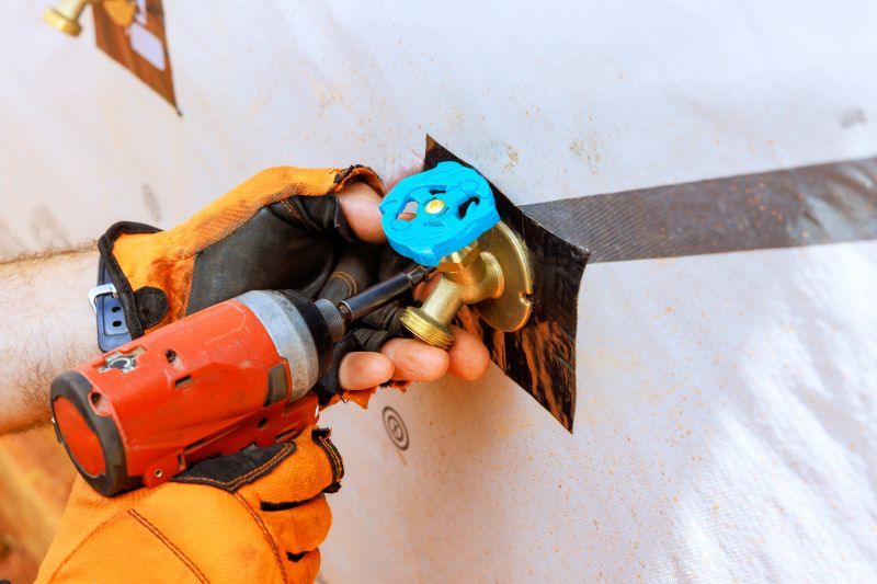 Plumber working on outdoor faucet